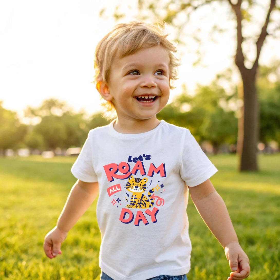 Toddler wearing CIASARA let's roam all day shirt with tiger print playing outdoors on grass