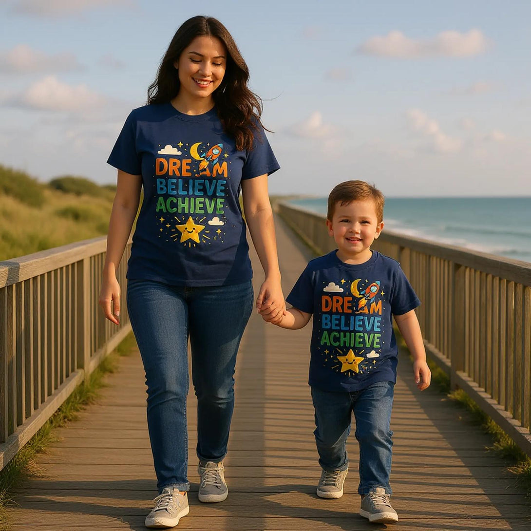 CIASARA mom and son in matching navy Dream Believe Achieve tees walking on boardwalk by ocean cute inspirational kids tee